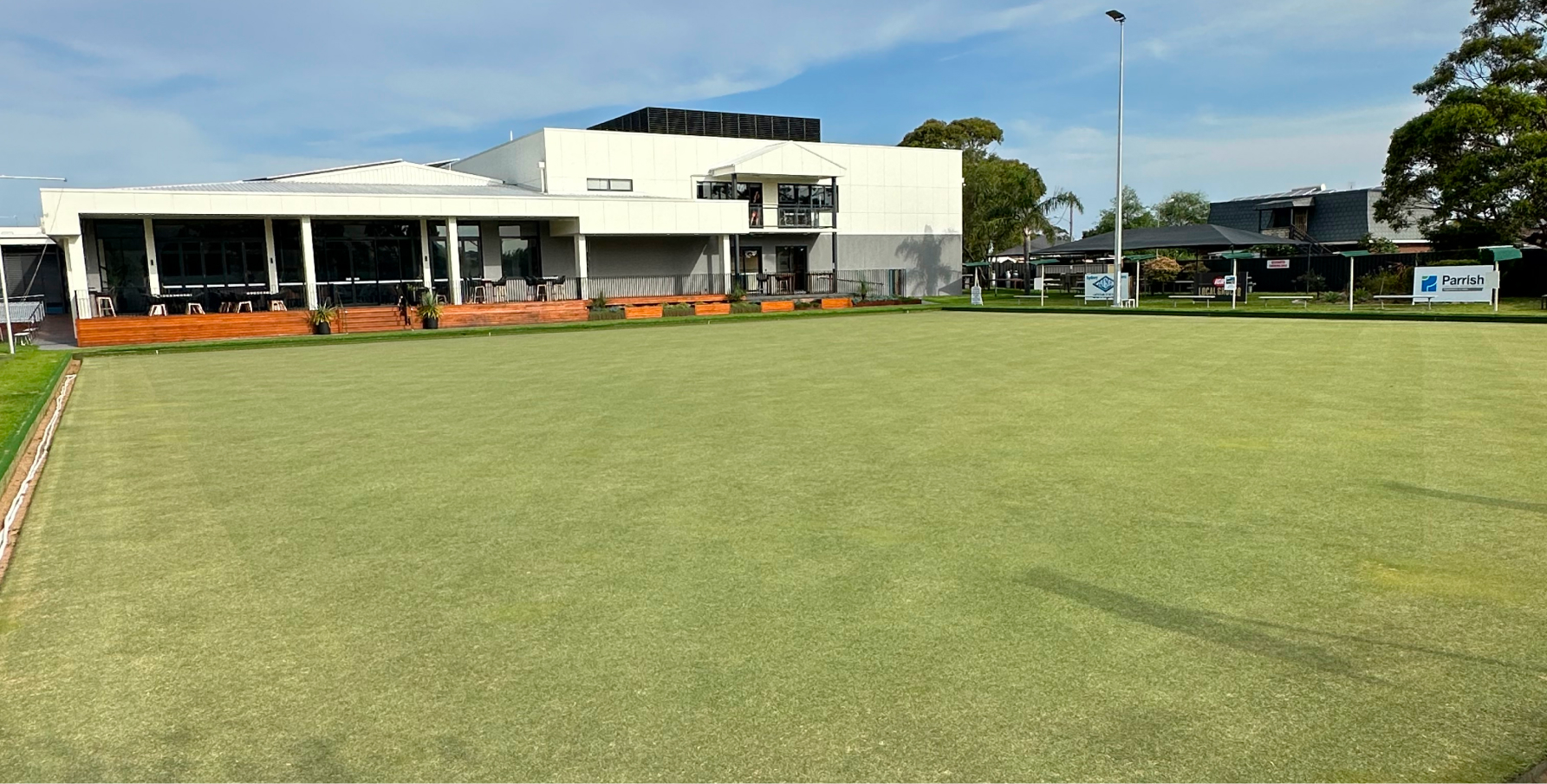A bowling club lawn with the clubhouse in the background